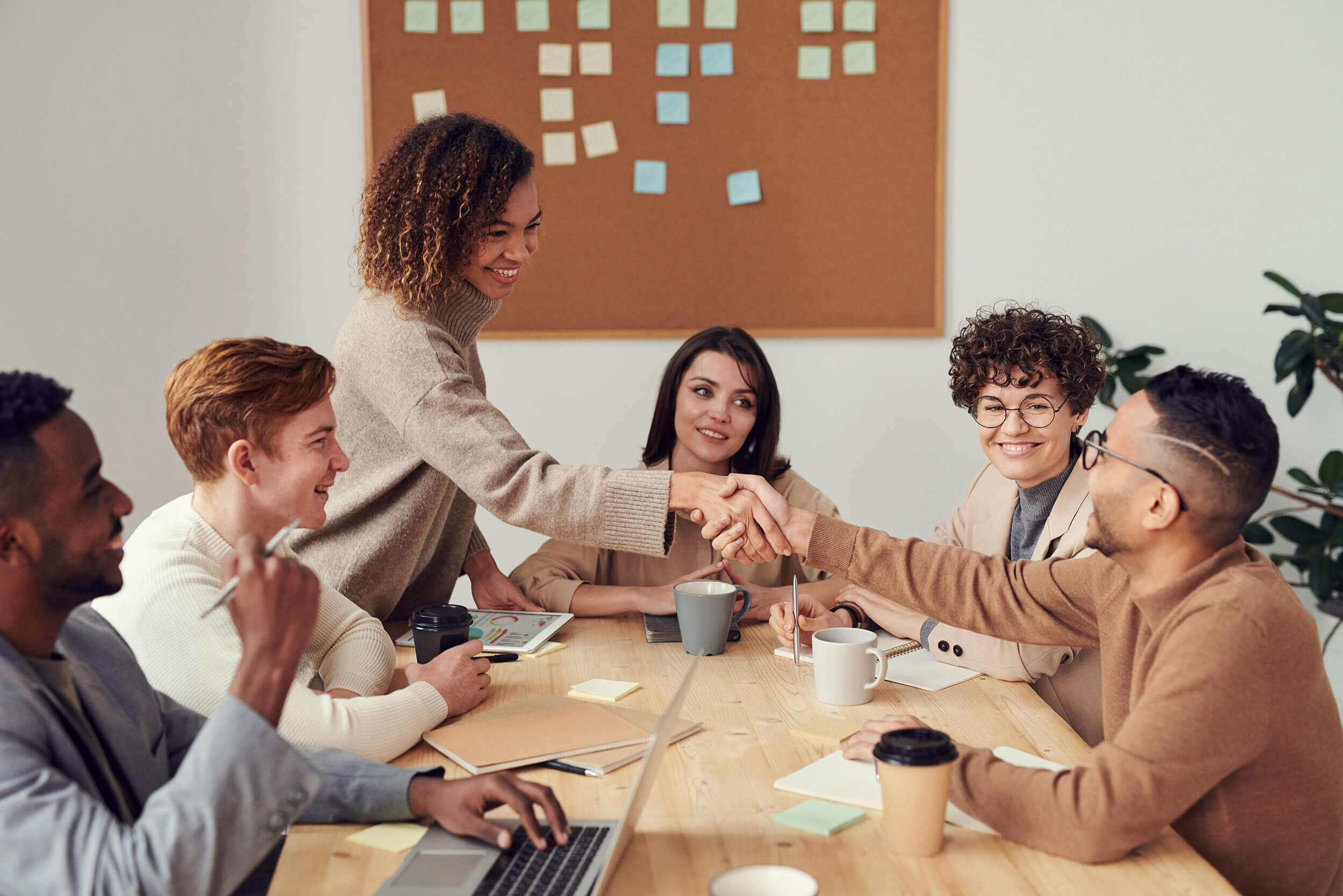 People shaking hands at group meeting.